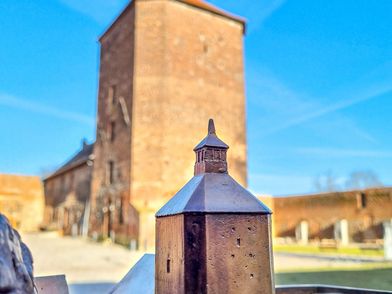 Blick auf ein Miniatur-Modell des Burgfrieds mit Blick auf den echten Burgfried im Hintergrund.
