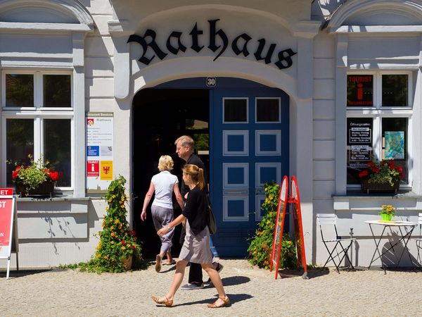 2 Personen laufen vor dem Rathaus Beeskow