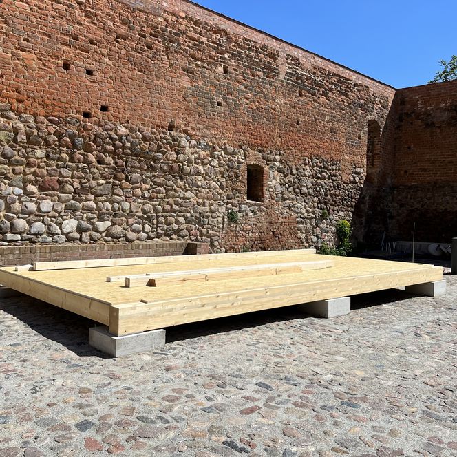 alte Mauer und davor fertiger Holzboden der Burghofbühne