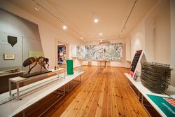 Ausstellungsraum im HIntergrund Landkarte und Objekte im Vordergrund